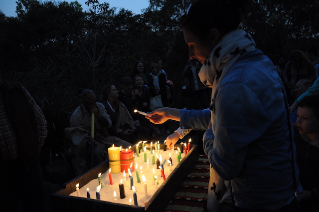 Person lighting candle at dusk